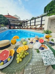 ein Obstbuffet auf einem Tisch neben dem Pool in der Unterkunft Apartments Miljas in Dubrovnik