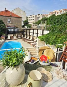 a balcony with a table with food and a swimming pool at Apartments Miljas in Dubrovnik