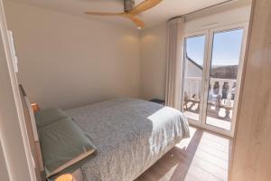 een slaapkamer met een bed en een groot raam bij Exquisita Villa Frente al Mar in Sagunto
