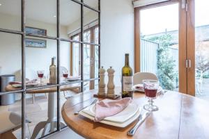 einen Tisch mit einer Flasche Wein und einem Glas in der Unterkunft Pebbles Cottage, Southwold in Southwold + 5 Fotos