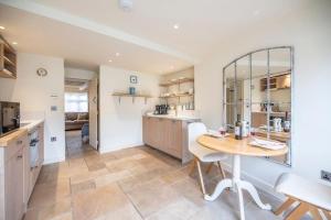 a kitchen with a table and a dining room at Pebbles Cottage, Southwold in Southwold