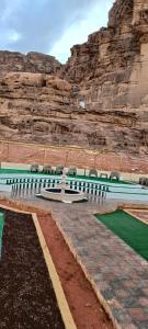 un groupe de bancs devant une montagne dans l'établissement Rum titanic camp, à Wadi Rum