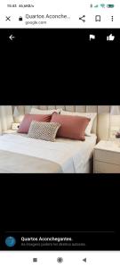 uma foto de uma cama com duas almofadas em QUARTOS ACONCHEGANTES.. em Jaraguá do Sul