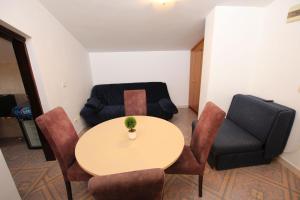um quarto com uma mesa e cadeiras e um sofá em Magnolia rooms and apartments em Sutomore