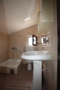 a bathroom with a sink and a toilet and a tub at Magnolia rooms and apartments in Sutomore