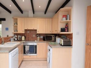 a kitchen with wooden cabinets and white appliances at 2 Bed in St Agnes 50085 in St. Agnes