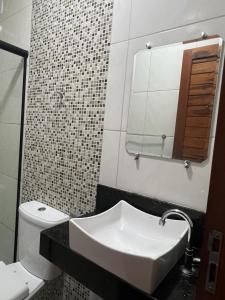 a bathroom with a sink and a toilet and a mirror at Chalé Guaramiranga-CE in Guaramiranga +25 photos