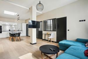 sala de estar con sofá azul y cocina en 189 Suite Nine - Superb apartment in Paris en París
