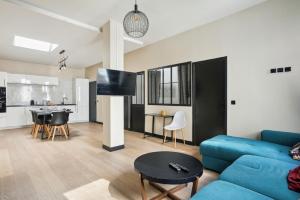 a living room with a blue couch and a kitchen at 189 Suite Nine - Superb apartment in Paris in Paris