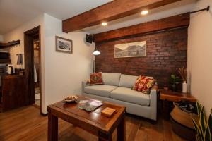 a living room with a couch and a brick wall at The Frenchman Suites in Silverton