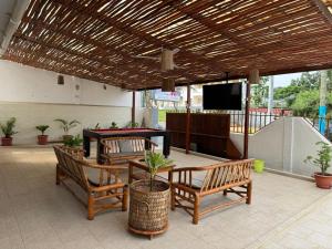 a patio with chairs and a table and a television at Paradise Agua Leve Residential in São Tomé