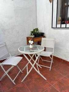 une table avec deux chaises et une table avec des fleurs. dans l'établissement La Casita Amarilla en Salta, à Salta