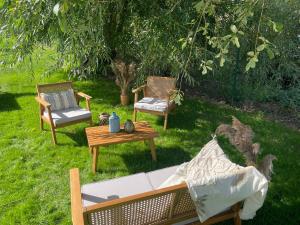 dos sillas y un sofá y una mesa en un patio en Omer Tiny, en Saint-Omer