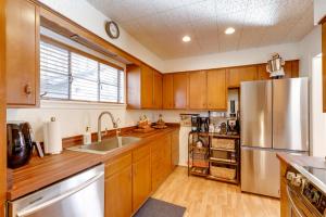 a kitchen with wooden cabinets and a stainless steel refrigerator at Williams Cottage with Patios and Grill Near Route 66 in Williams
