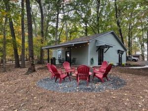 un groupe de chaises rouges et une table devant une cabine dans l'établissement 3 Bedroom Cottage with feel of being in nature., à Indian Trail