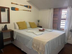 a bedroom with a large white bed with yellow pillows at Malai Beach in Jericoacoara