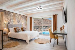 a bedroom with a bed and a desk and a window at Etti - Paradise Suite La Roca in La Lajita +20 photos