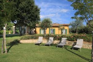 a group of chairs sitting in the grass in front of a house at AD MY HOME in Cortona
