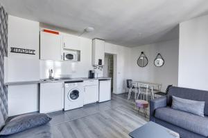 a kitchen and living room with a couch and a table at 803 Suite Parisian - Superbe appartement in Bagnolet
