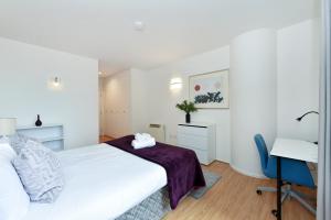 una camera con letto, scrivania e computer di London Choice Apartments - South Kensington - Gloucester Road a Londra