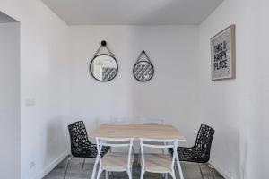 a dining room table with chairs and a mirror at 803 Suite Parisian - Superbe appartement in Bagnolet