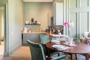 a kitchen and dining room with a wooden table and chairs at Boutique Home Stay - Bliss Studio in Paisley