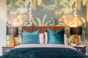 una camera da letto con un letto con cuscini blu e carta da parati tropicale di Boutique Home Stay - Bliss Studio a Paisley