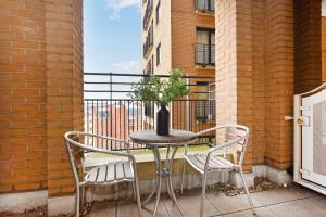 un tavolo e sedie su un balcone con un vaso di London Choice Apartments - South Kensington - Gloucester Road a Londra