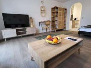 a living room with a bowl of fruit on a coffee table at Studio-Priv.Parkplatz-Balkon-Wlan-Netflix-SmartTV in Deizisau