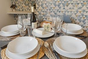 867-Suite Mimosa - Superb Apartment في مونتروي: طاولة مع أطباق وأكواب وزجاجة من النبيذ