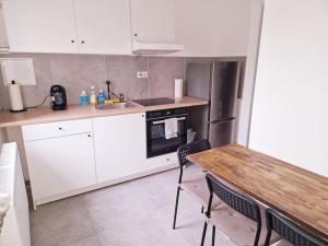 een keuken met witte kasten en een houten tafel bij City Apartment in Bremerhaven