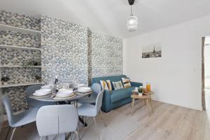 867-Suite Mimosa - Superb Apartment في مونتروي: غرفة معيشة مع طاولة وأريكة زرقاء