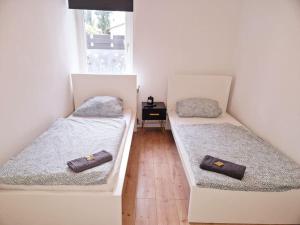 twee eenpersoonsbedden in een kamer met een raam bij City Apartment in Bremerhaven