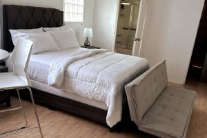 ein Schlafzimmer mit einem großen Bett und einem Stuhl in der Unterkunft Eagles Nest Villa Studio AC TV WIFI Fan Luxury Modern in Albion