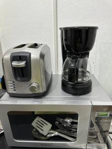 einen Toaster und eine Kaffeemaschine auf der Mikrowelle in der Unterkunft Eagles Nest Villa Studio AC TV WIFI Fan Luxury Modern in Albion