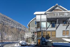 特柳賴德的住宿－This Three Bedroom Condo Boasts Great Views of the Ski Area!，雪中的房子,前面有停车位