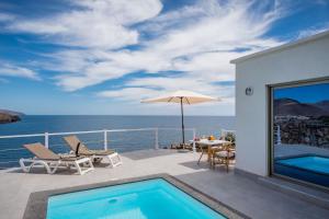 a patio with a swimming pool and an umbrella at Etti - Paradise Suite La Roca in La Lajita