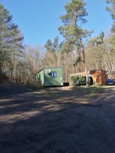 a green trailer sitting on the side of a road at Haus "Blücher" TinyHouse Mobilheim in Stuer