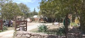 un jardín con valla y árboles y un edificio en Cabañas Campo Dulce Esperanza en Bialet Massé