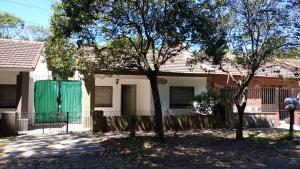 a house with a green gate and two trees at Salta Paradise in San Bernardo