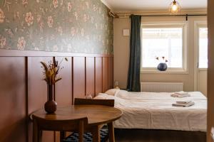 a bedroom with a bed and a table and a window at Glaskogen Apartments in Glava