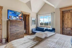 une chambre avec un grand lit et un canapé bleu dans l'établissement Cabin~Views~Heart of Town~W&D~Fireplace~Kitchen, à Woodland Park