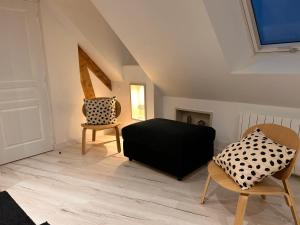 een woonkamer met een zwarte bank en 2 stoelen bij Rance Solidor in Saint-Malo
