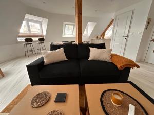 - un salon avec un canapé noir et une table dans l'établissement Rance Solidor, à Saint-Malo