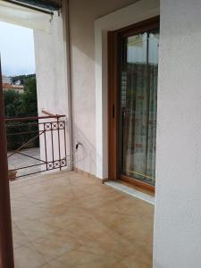 een kamer met een deur en een balkon met een raam bij ENJOY APARTMENT in Ovriá