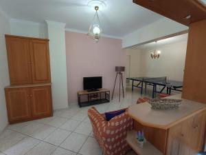 een woonkamer met een bank en een tafel bij ENJOY APARTMENT in Ovriá