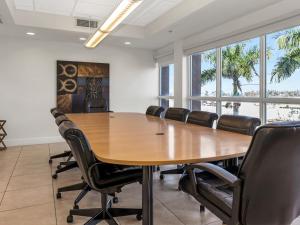 een conferentieruimte met een grote houten tafel en stoelen bij South River Suites in Medley