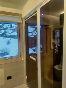 eine Glasdusche im Bad mit Fenster in der Unterkunft Tana della Marmotta - turkish bath, garage, and storage in Breuil-Cervinia