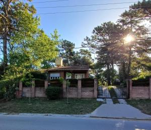 a brick house with the sun shining on it at Nuestro Lugar in Villa Gesell