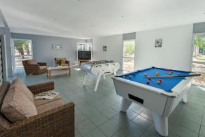 - un salon avec un billard et un canapé dans l'établissement Lagrange Vacances L'Estuaire, au Le Verdon-sur-Mer